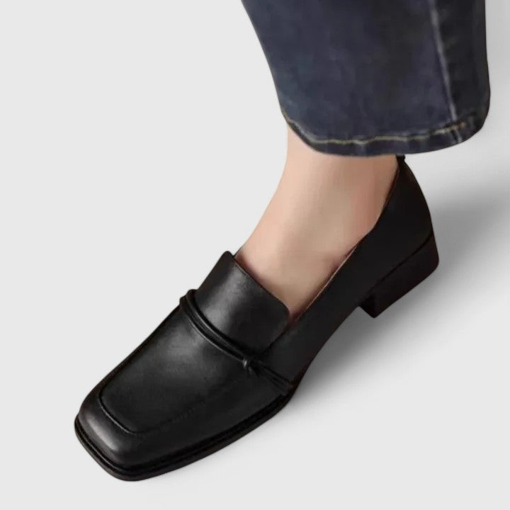 Black square toe loafer with low block heel and penny strap, worn with jeans
