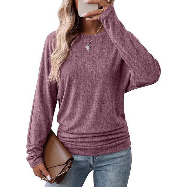Woman wearing a mauve batwing crew neck sweater with ruched hem