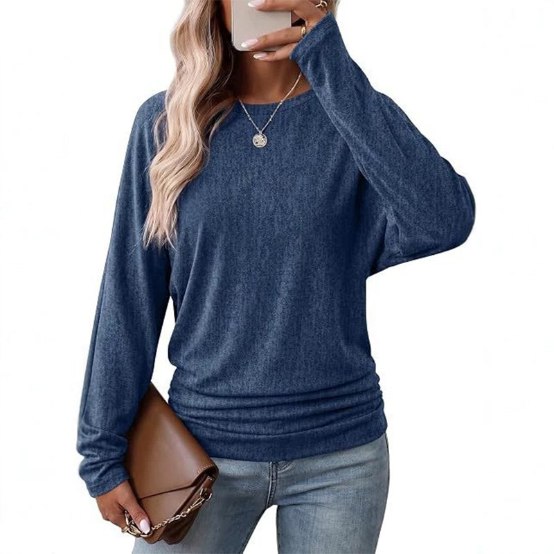 Woman wearing a royal blue batwing crew neck sweater with ruched hem