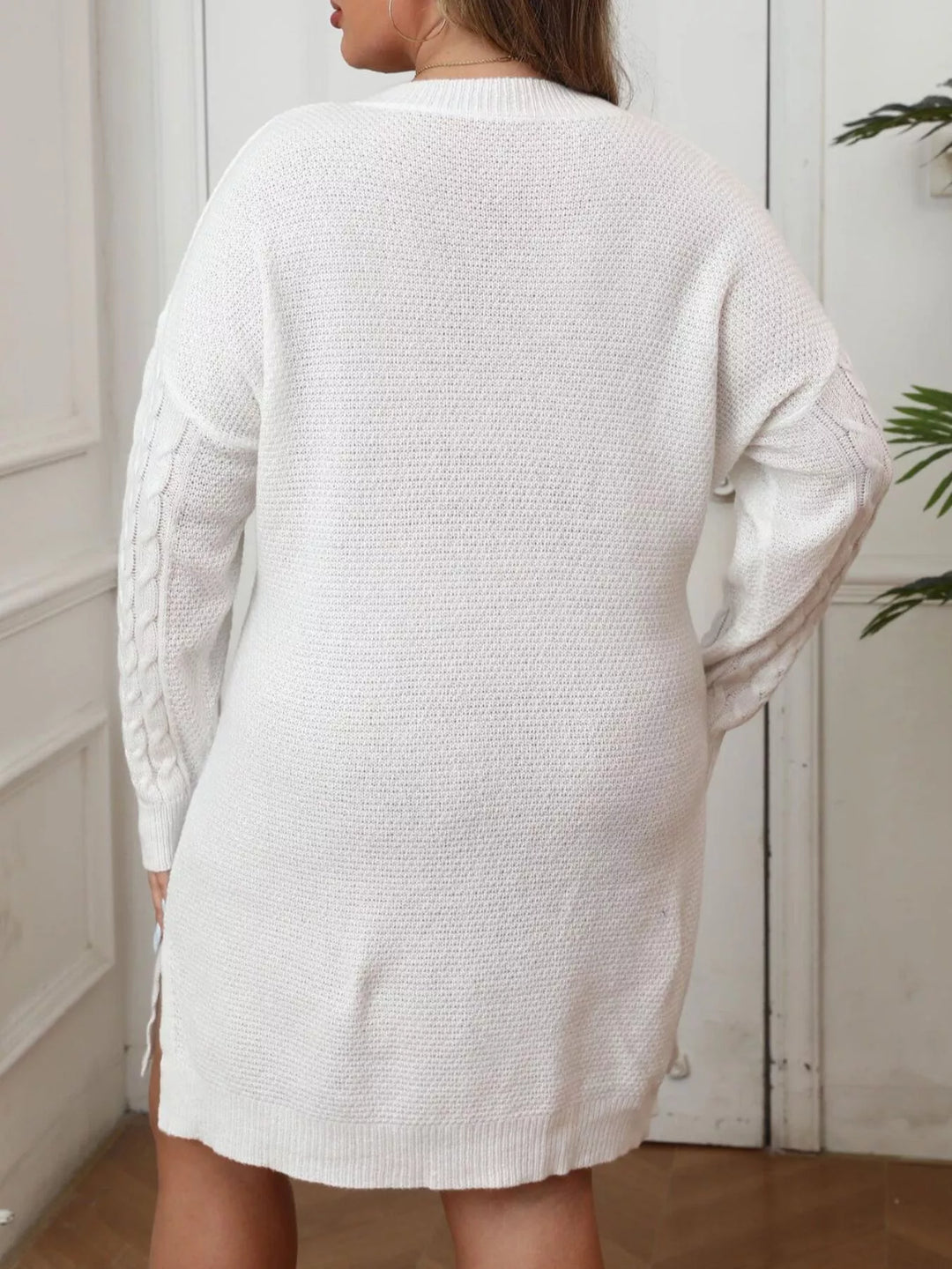 Back view of the white sweater dress with dropped shoulders and a plain knit back