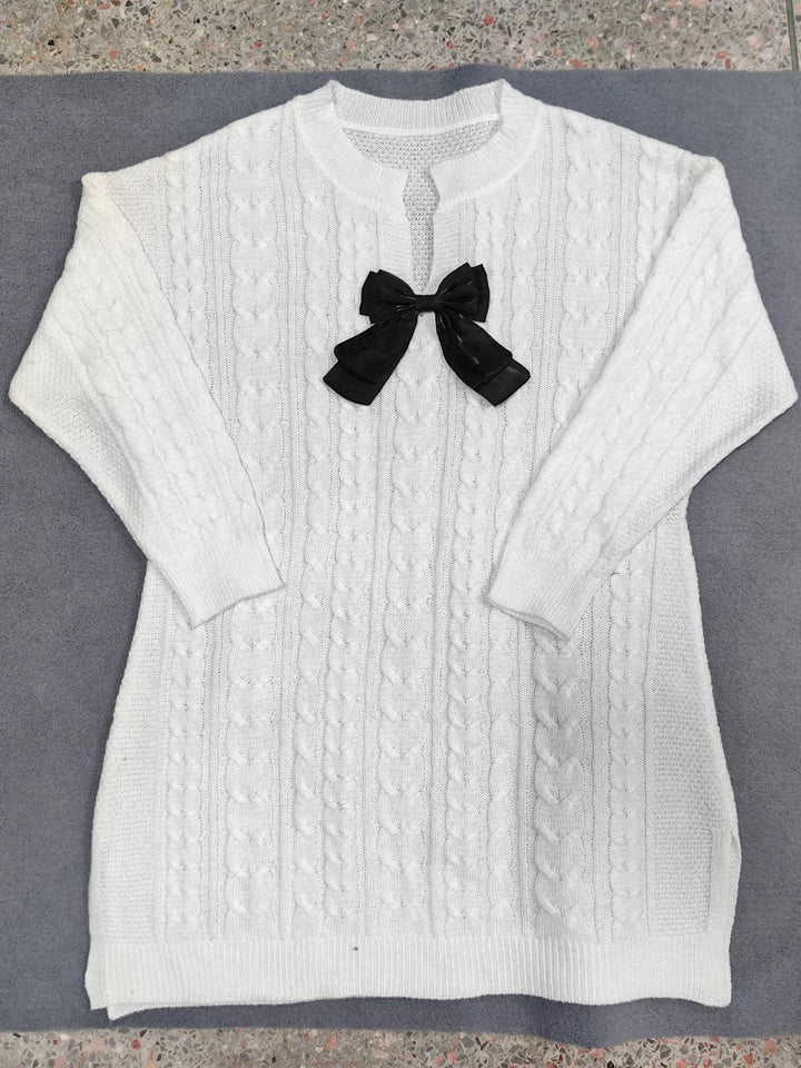 Flat lay of the white cable knit dress showing the bow and side slits