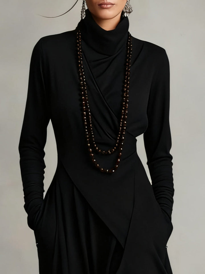 Close-up of the black draped bodice and turtleneck with beaded necklace