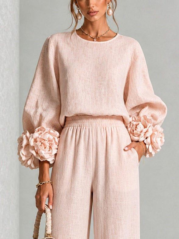 Close-up of the pink knit top with gathered waist and flower-like ruffle cuffs