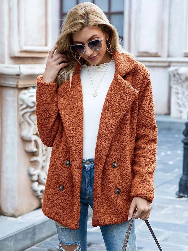 Caramel orange teddy coat worn open, hip length with double breasted buttons