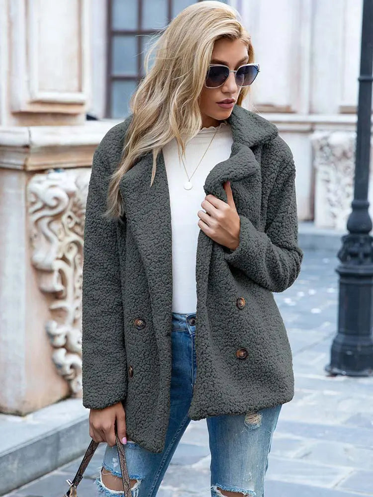 Gray hip length teddy coat styled with jeans in a city street setting
