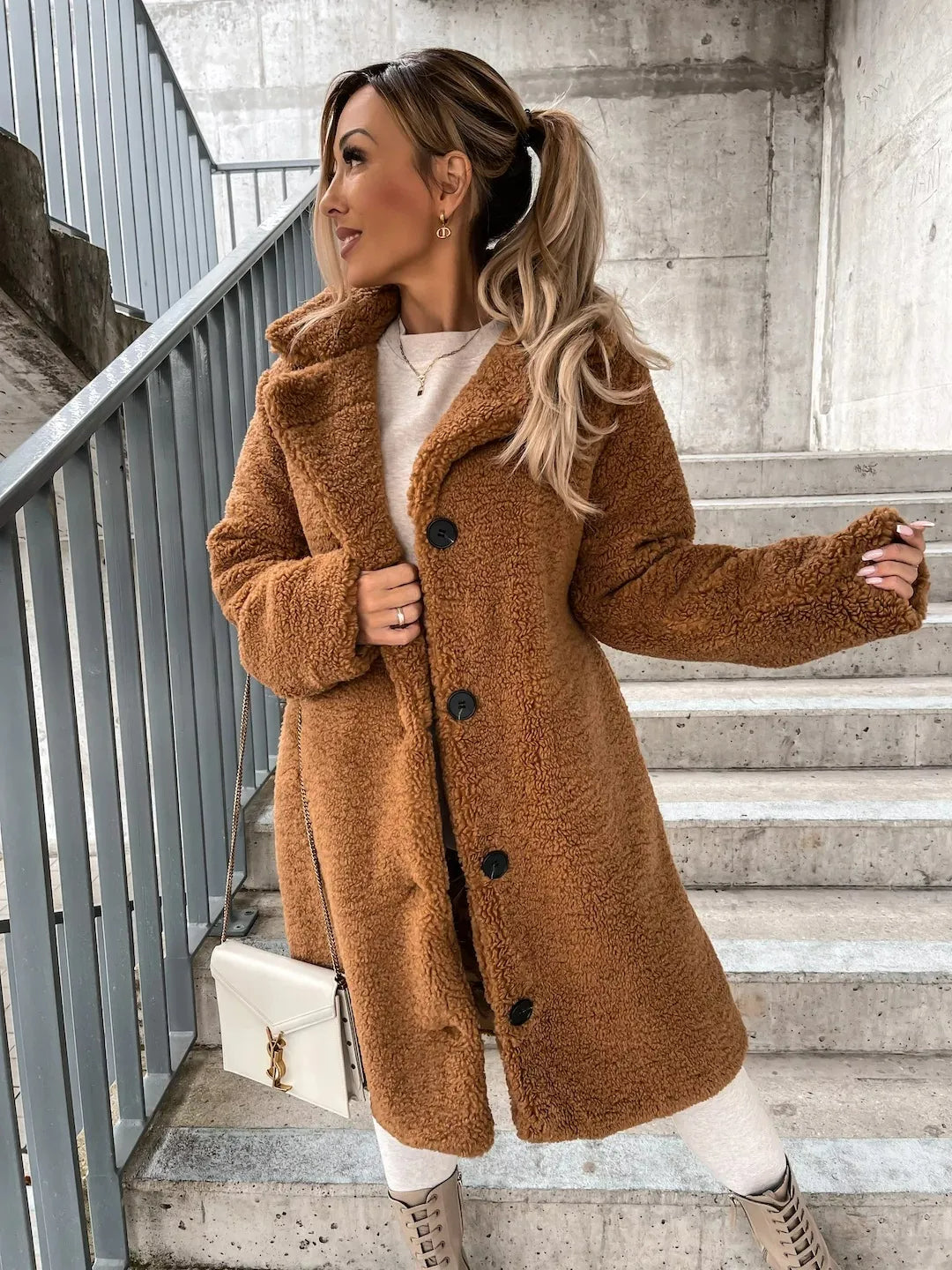 Caramel long teddy bear coat buttoned up, model posing on a staircase
