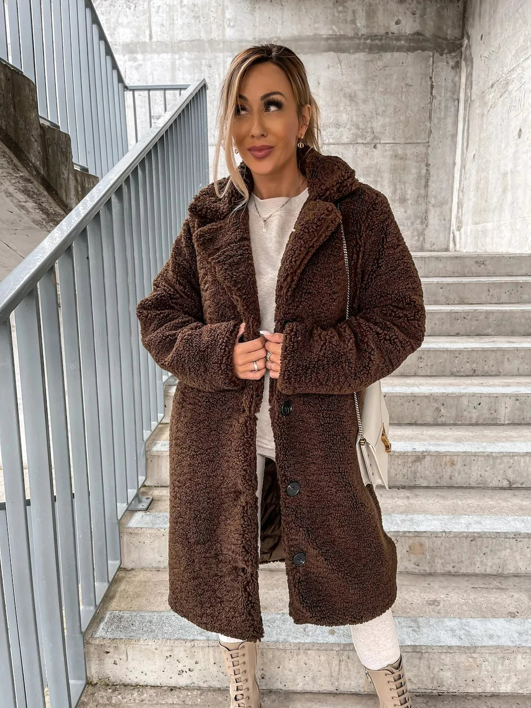 Chocolate teddy coat styled with white leggings and beige chunky boots