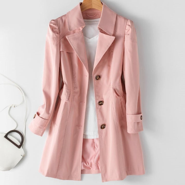 Pink mid length trench coat with button cuffs, front view on a hanger
