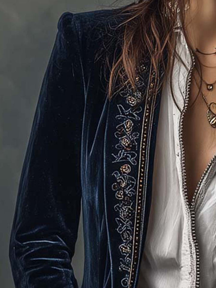 Close-up of the navy velvet-look jacket shoulder and open front over a white shirt