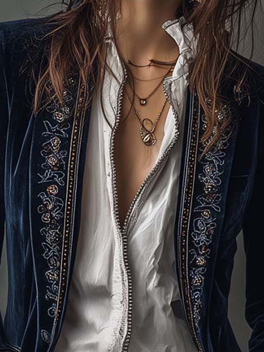 Close-up of the embroidered lapel edge on the navy velvet-look jacket