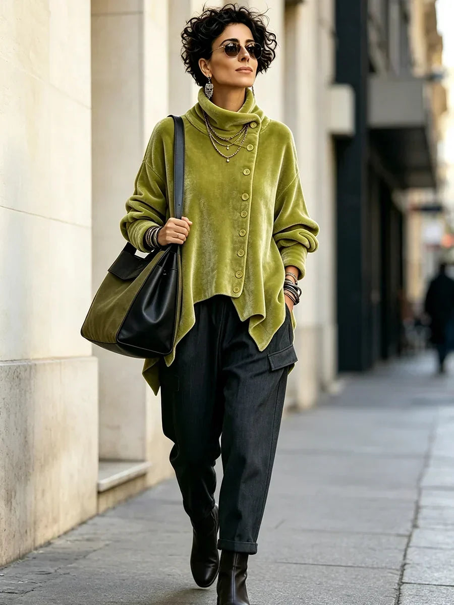 Model walking along a city street in the olive green oversized turtleneck top