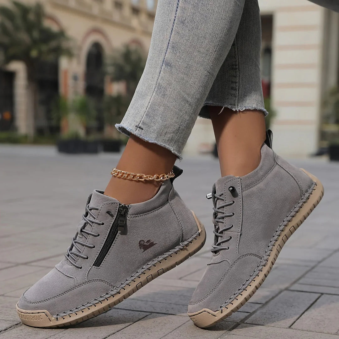 Women's walking shoes in gray, stitched slip on with side zip worn with jeans