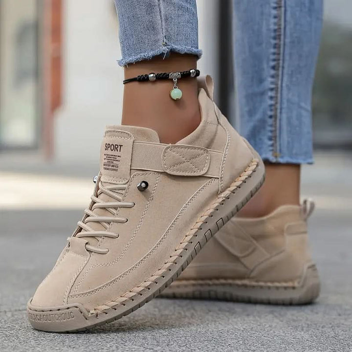 Beige walking shoes outdoors, worn with jeans and a beaded ankle bracelet