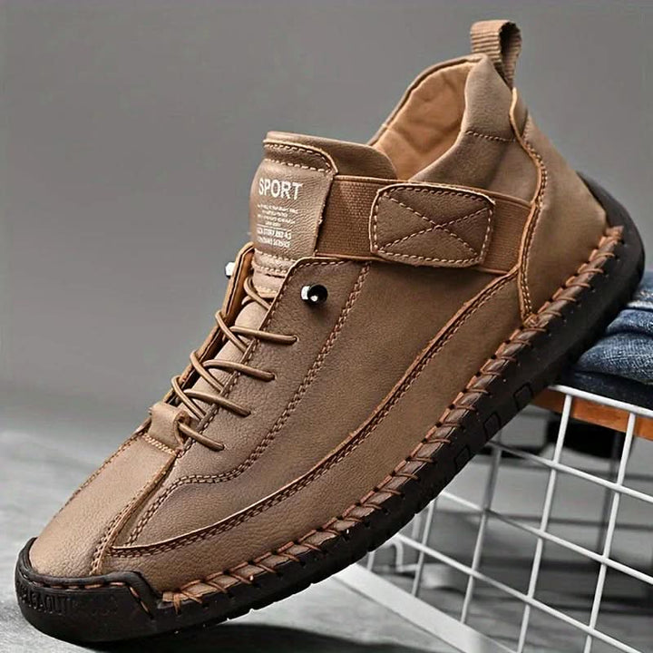 Brown sport sneaker in side view with strap, laces and hand stitched sole
