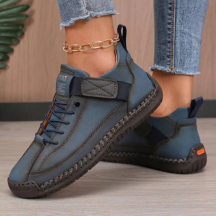 Steel blue sneakers with strap and laces, worn with frayed jeans and gold anklet