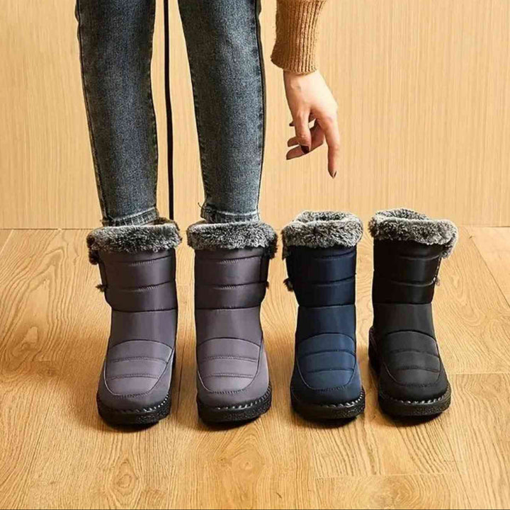 Gray, navy and black faux fur cuff ankle boots lined up on a wood floor
