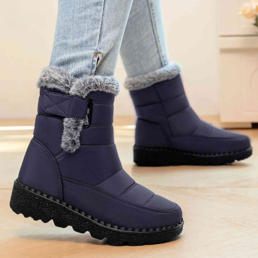 Navy ankle boots with faux fur cuff and strap closure, worn with jeans