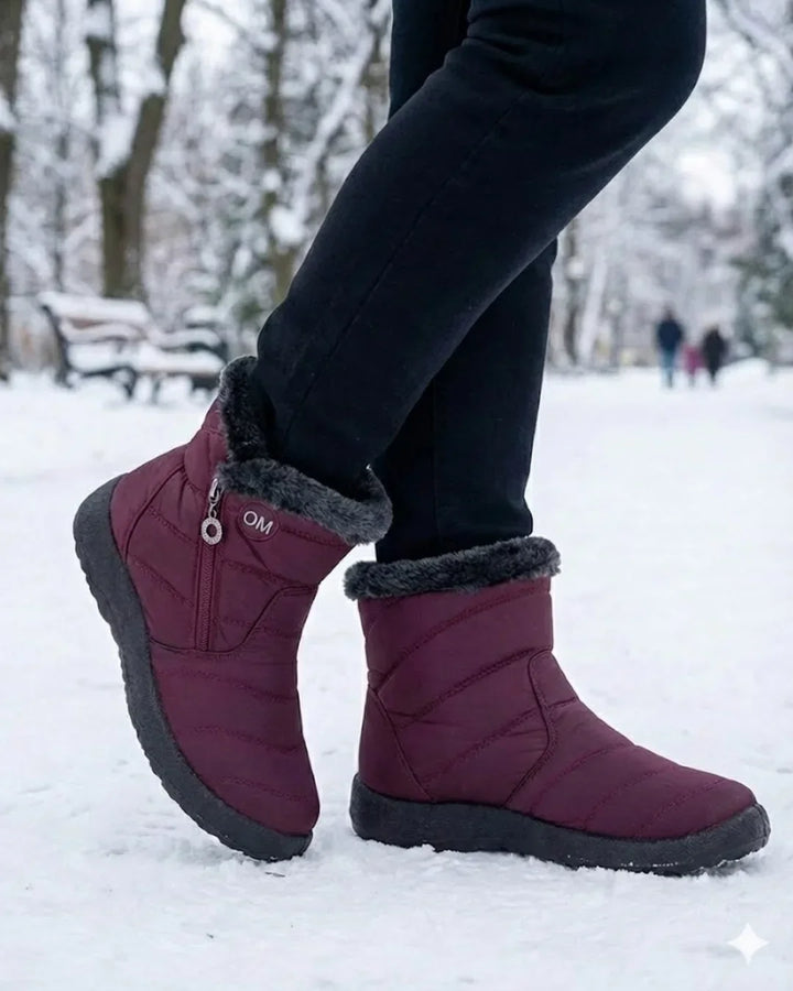 Burgundy zip ankle boots worn with black pants in the snow