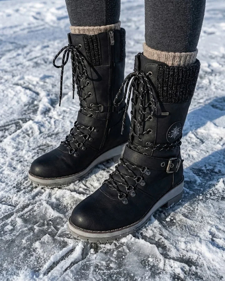 Black lace up boots with knit cuffs worn in the snow with gray socks