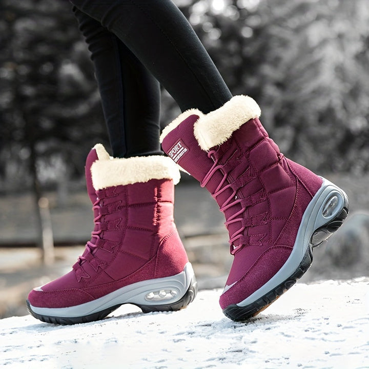 Burgundy mid calf boots in motion, shown from the side on snow