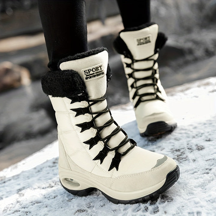 Cream lace up mid calf boots worn on snow with black leggings
