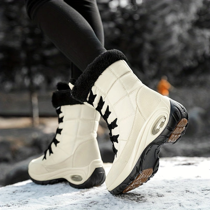 Cream platform boots with black laces, worn on a snowy path