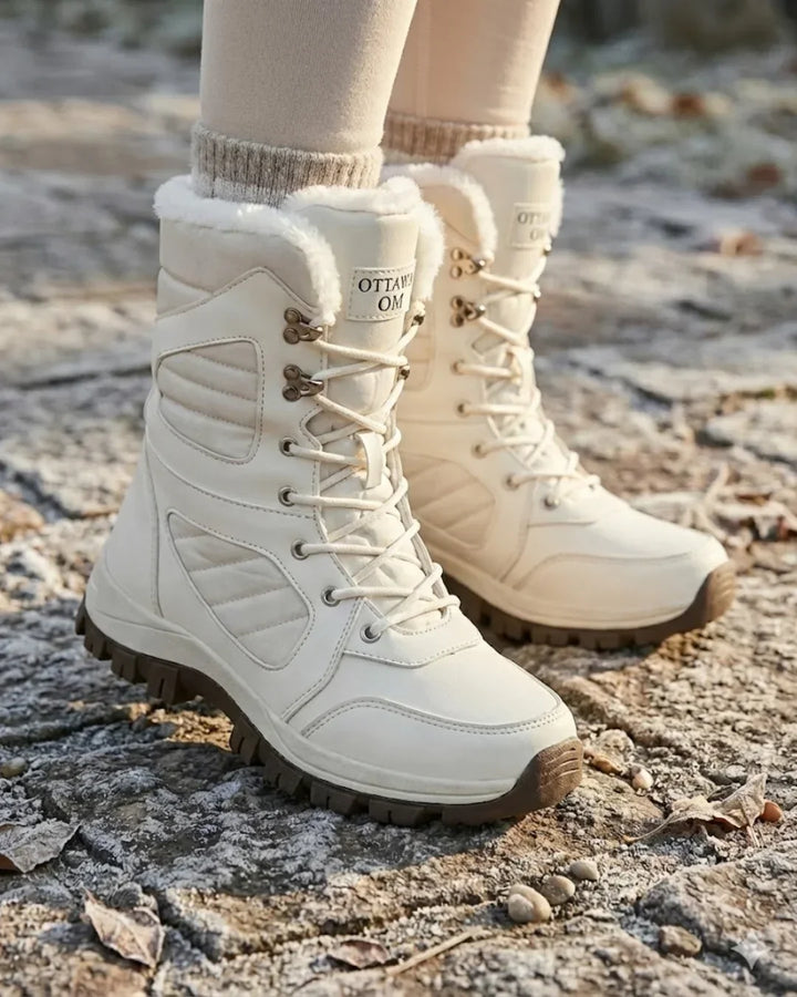 Cream lace up boots worn outdoors on frosty ground with leggings