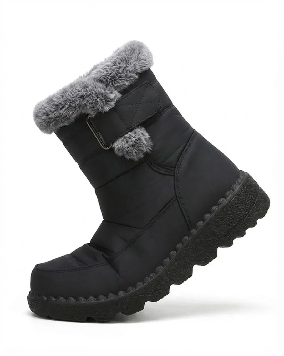 Black quilted boot angled to show the strap, pom-pom and faux fur trim