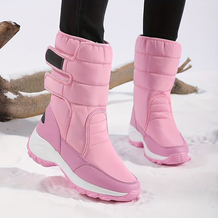 Pink quilted double strap boots with a thick white sole on snow