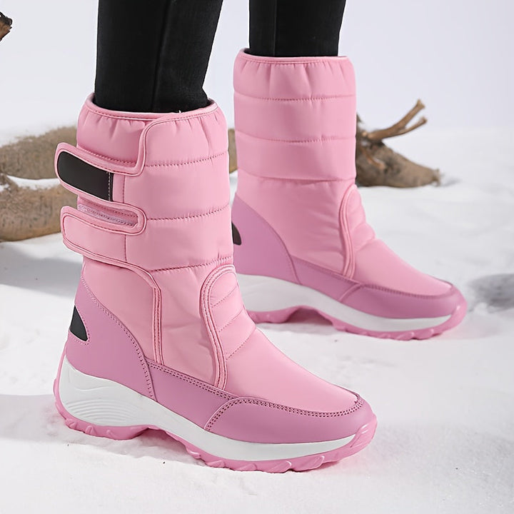 Pink double strap mid calf boots on model standing in snow