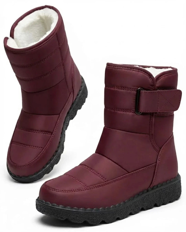 Pair of burgundy quilted mid calf boots with a wide strap