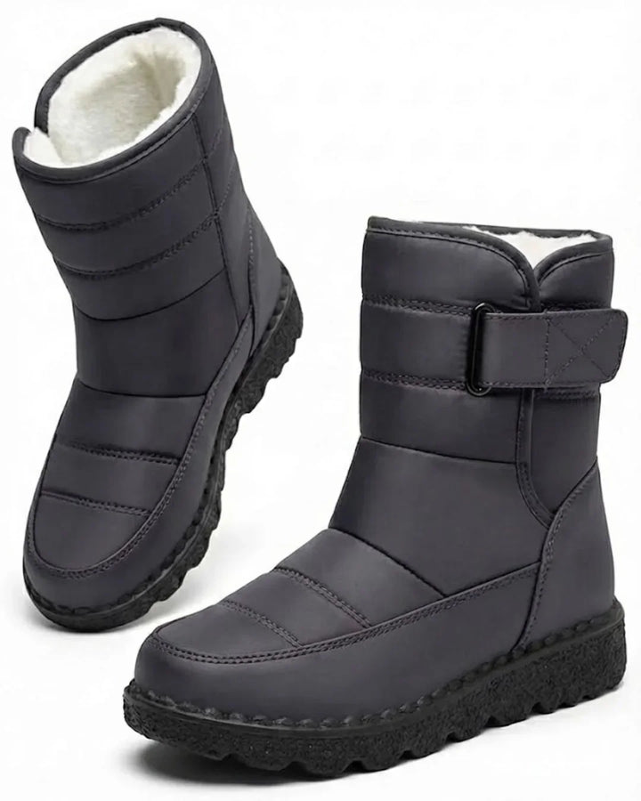 Pair of gray quilted mid calf boots with a wide strap