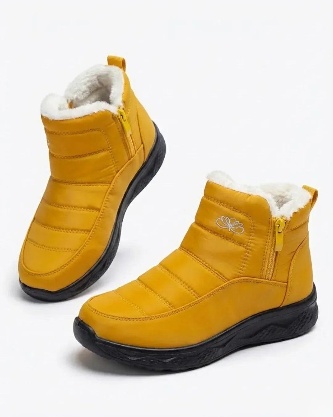 Pair of mustard yellow quilted ankle boots with side zip and plush trim