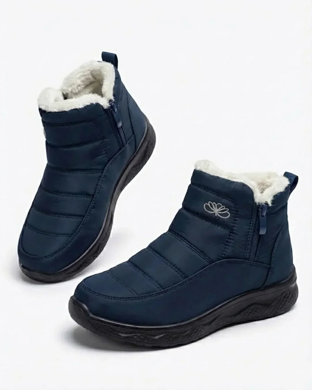 Pair of navy quilted side zip ankle boots with white teddy collar