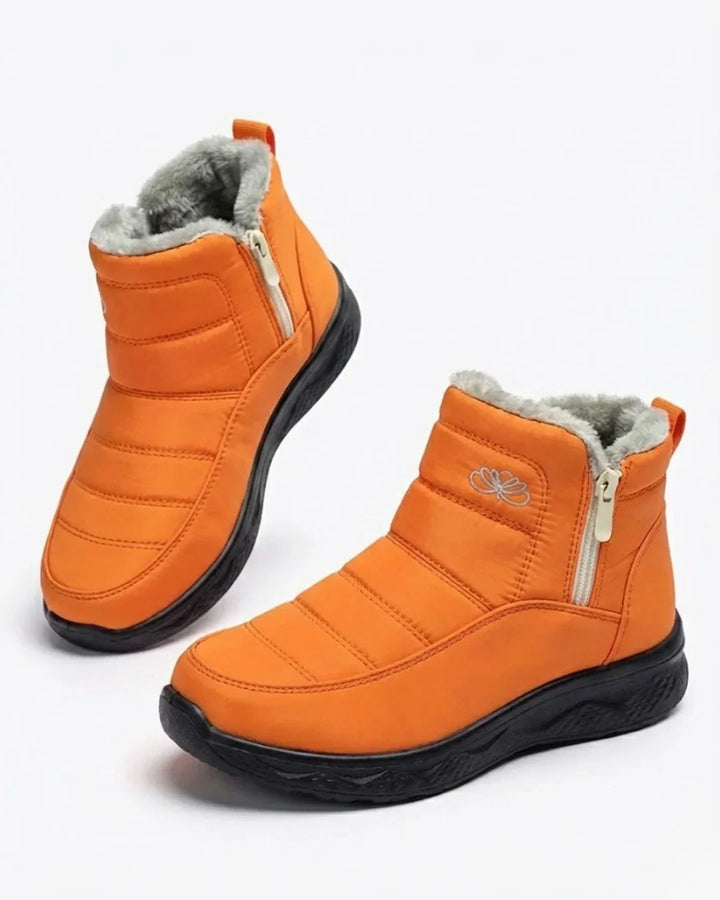 Pair of orange quilted side zip ankle boots with teddy collar