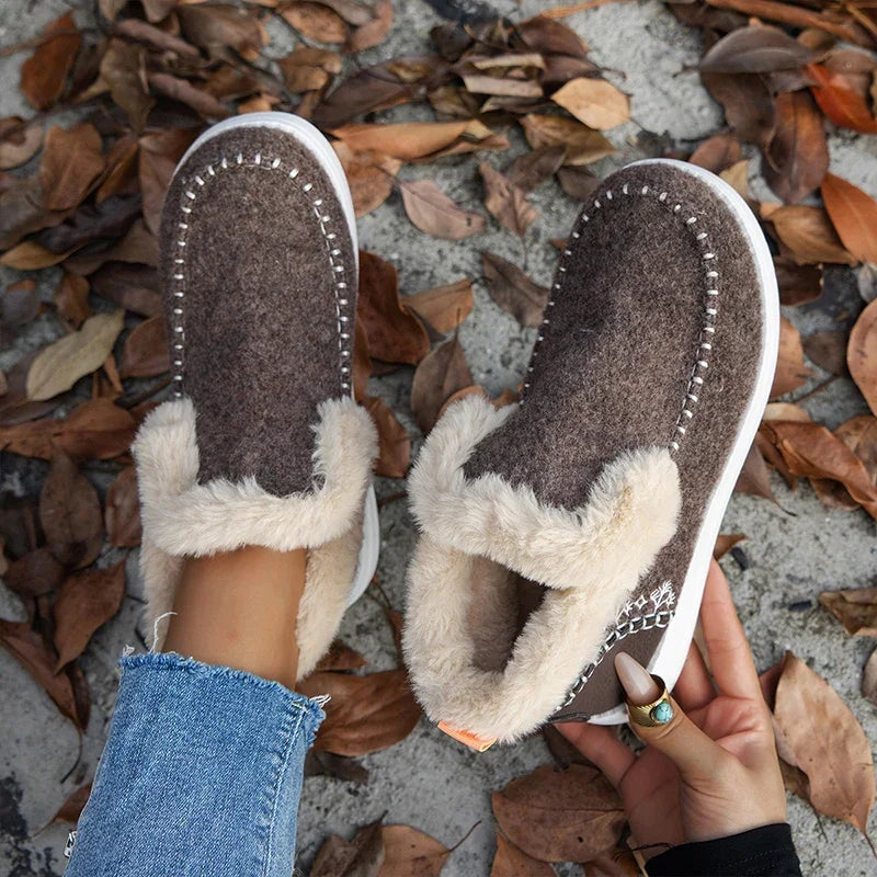 Top-down view of brown stitched slip on boots with cream faux fur collar