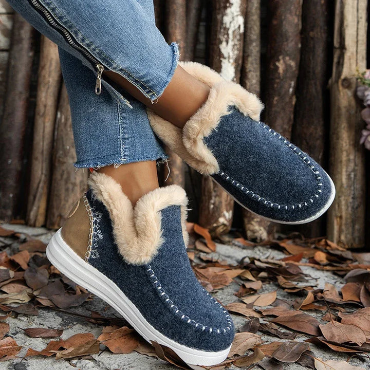 Navy stitched slip on ankle boot with faux fur collar, angled foot view