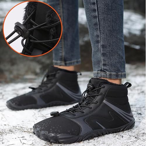 Black sporty ankle boots worn with jeans on snowy ground, lace detail inset