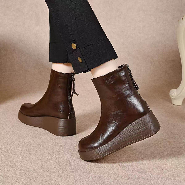 Brown platform wedge ankle booties with back zip worn with black pants with button hems