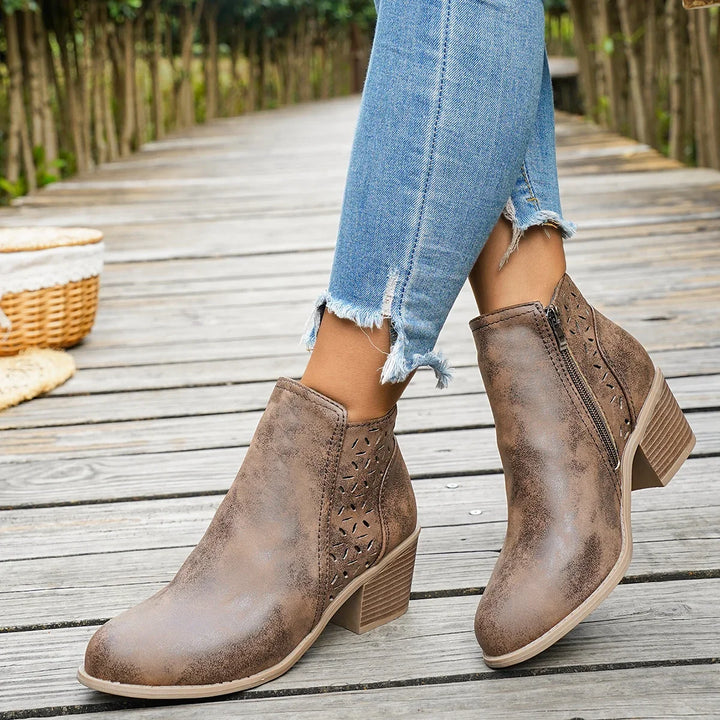 Brown perforated western ankle boots with block heel worn with cuffed jeans