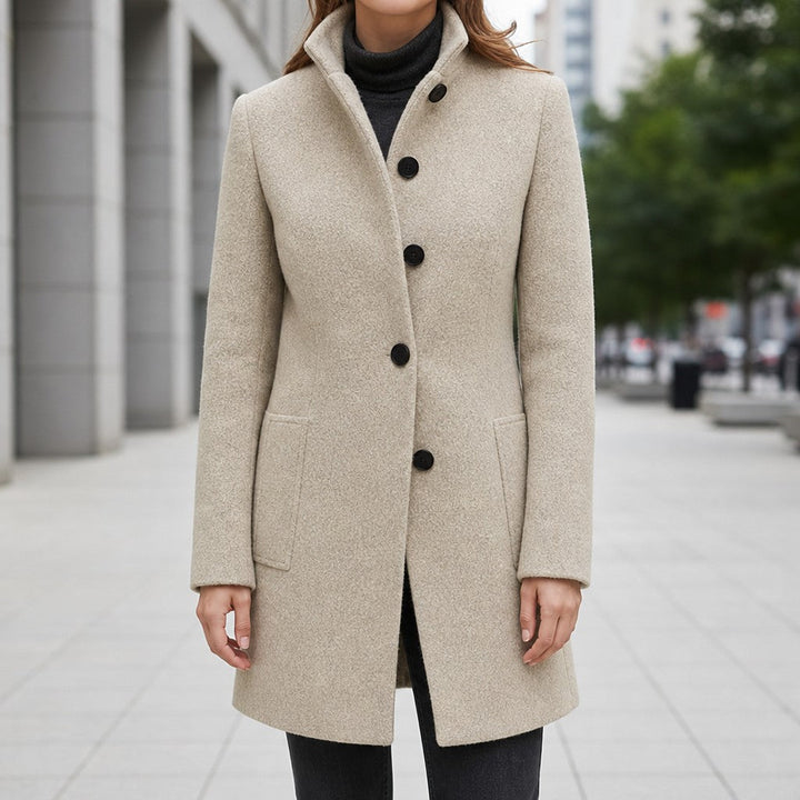 Oatmeal stand collar coat with large black buttons on a city street