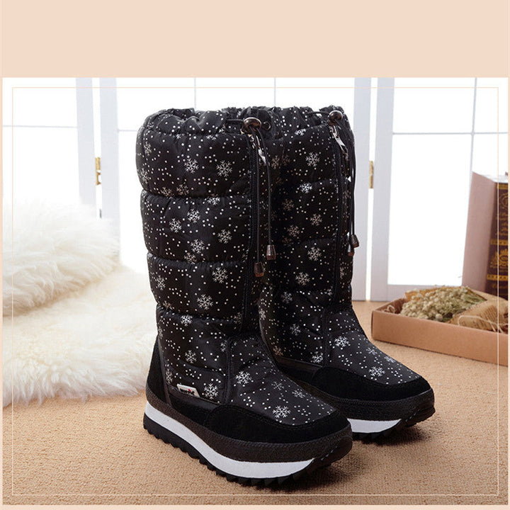 Black snowflake print snow boots styled indoors next to a soft white rug