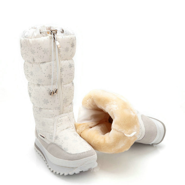 White quilted snow boot pair with one boot tipped to show the plush faux fur lining