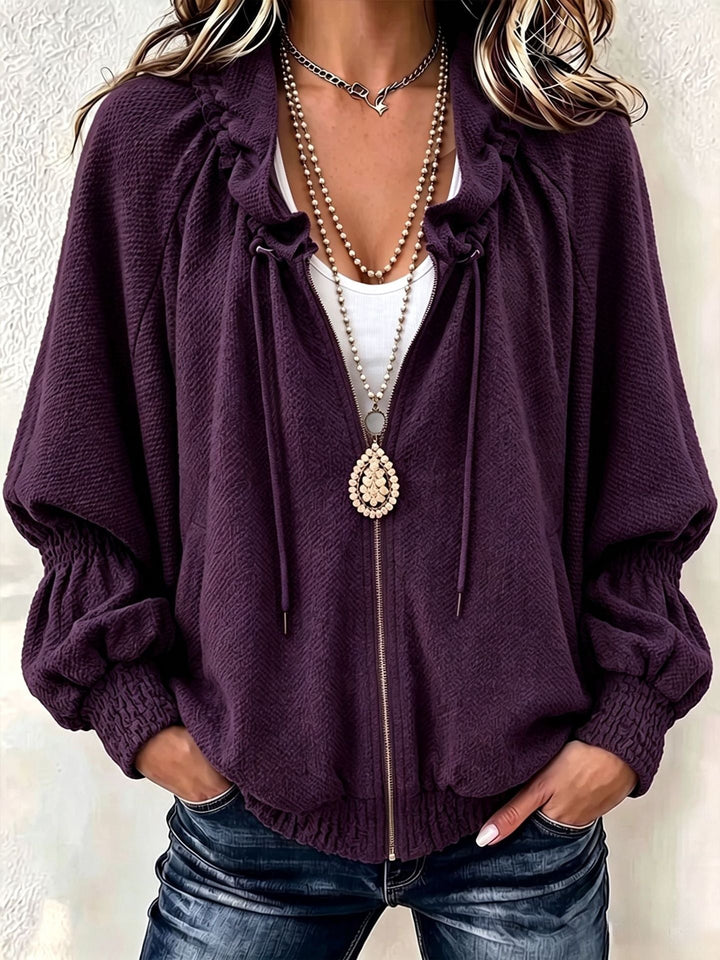 Purple zip jacket showing smocked cuffs and a gathered hem at the hips